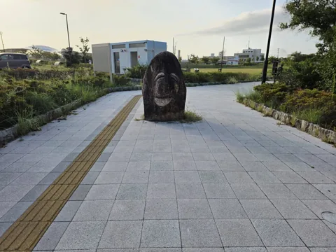 今之浦公園：点字ブロックと石のモニュメントがある園路