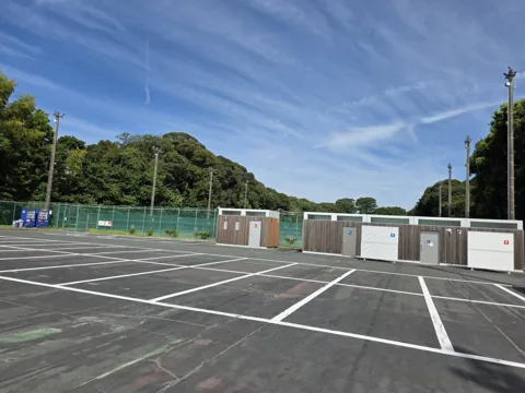 東大久保運動公園：駐車場。奥にユニット型のトイレ・倉庫