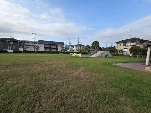 葦間公園：芝生広場から見た築山遊具とパーゴラ