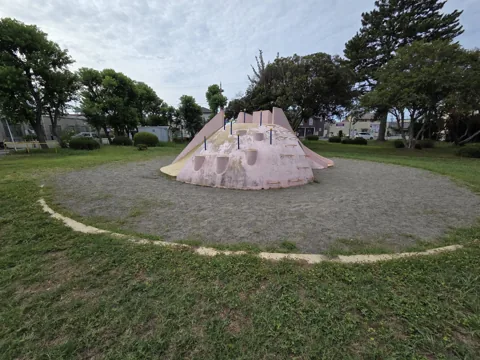 旭ヶ丘公園：中央の築山型すべり台（コンクリート製）と円形の砂地