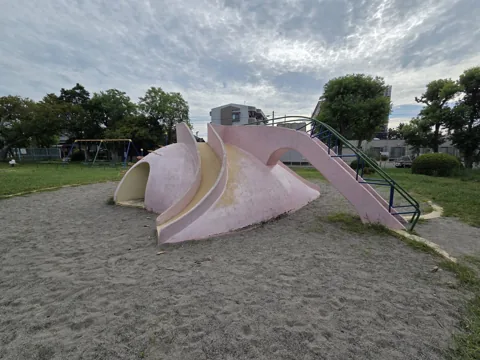 旭ヶ丘公園：築山型すべり台。トンネルと複数の滑走面、奥にブランコ
