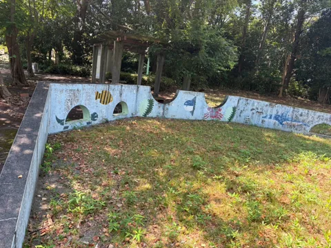 京見塚公園：絵が描かれた壁に囲まれた砂場