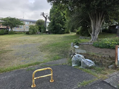 城之崎公園：車止めのある舗装入口と花壇