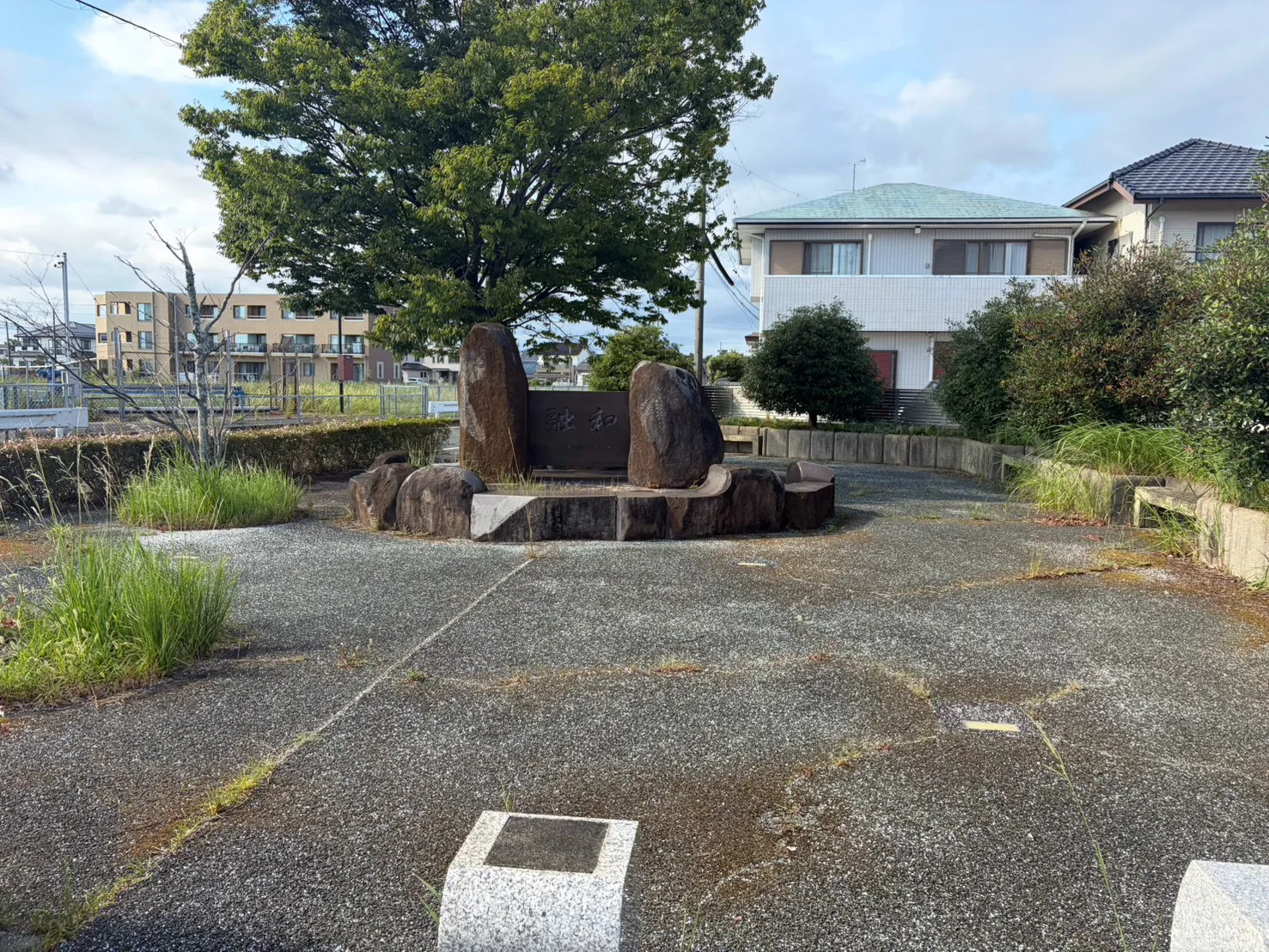 豊田第1緑地:中央の石碑と大きな木を正面から望む緑地全景