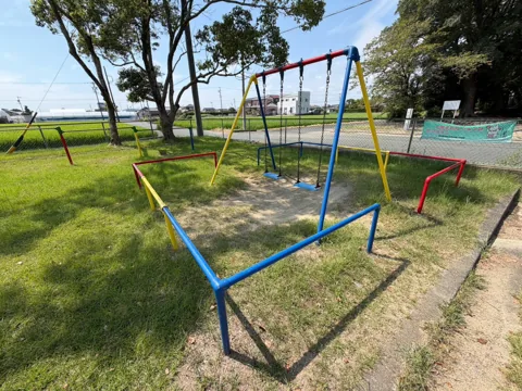 豊田富里農村公園：ブランコと鉄棒が並ぶ芝生の遊具広場