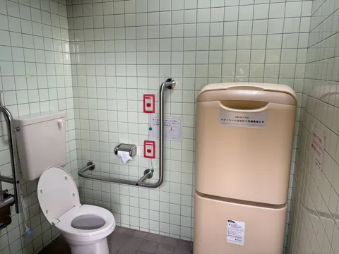 豊田原新田公園：多目的トイレ内部。洋式便器と手すり・ベビーシート