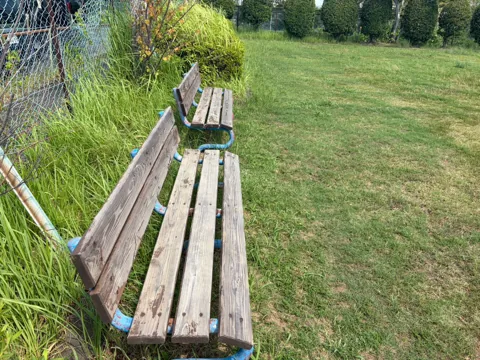 豊田森本農村公園：フェンス沿いの木製ベンチ