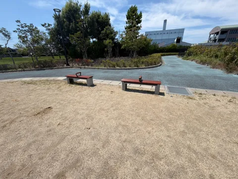 クリーンセンター公園：園内を巡る青い園路と広場沿いのベンチ