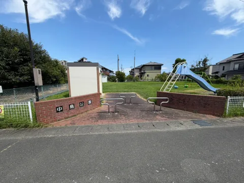 竜洋中島公園：レンガ壁の園名表示と滑り台が見える正面入口