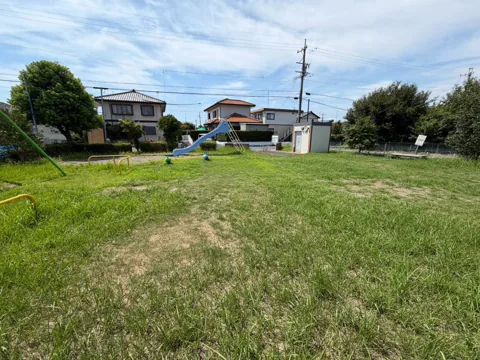 竜洋中島公園：広場越しに滑り台やブランコを望む園内全景