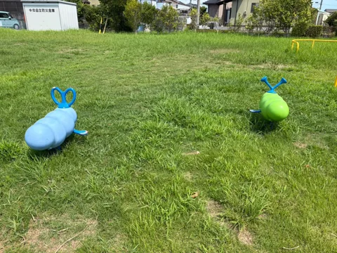 竜洋中島公園：芝生に並ぶ青と緑の幼児向けスプリング遊具