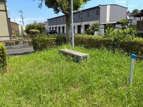 竜洋中島公園：植え込み沿いに設置された休憩ベンチ