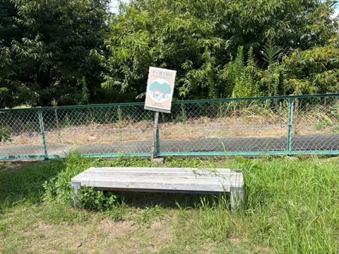 竜洋中島公園：フェンス沿いのベンチとボール遊び禁止の案内