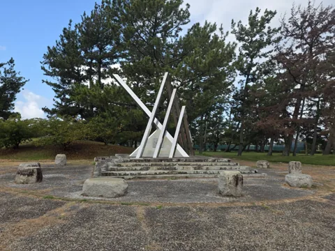 福田公園：白いモニュメントと石の腰掛けがある広場